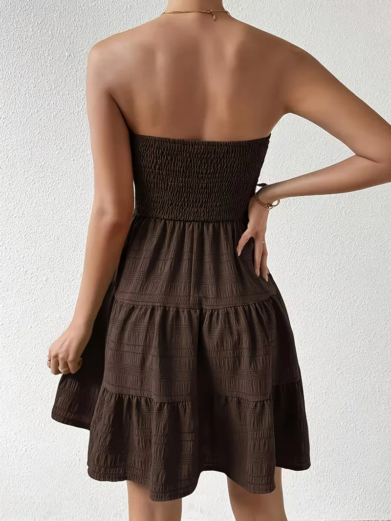 Achterkant van smocked strapless jurk met mini-lengte en volumineuze gelaagde rok