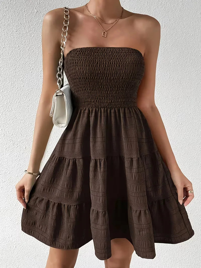 Detail van getextureerde stof en volants op gelaagde rok van strapless mini jurk