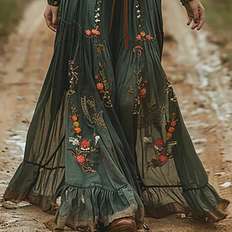 Zijaanzicht van geborduurde bohemian maxi jurk met wijdvallende geplooide rok en bloemendetails