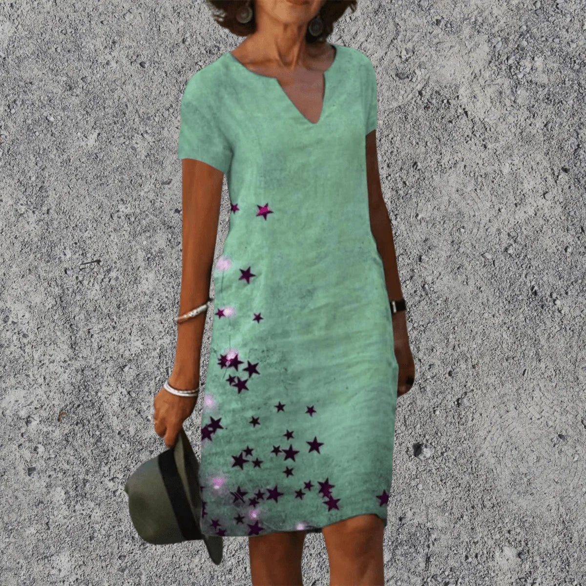 Vrouw in midi zomerjurk met bloemenprint gecombineerd met casual accessoires