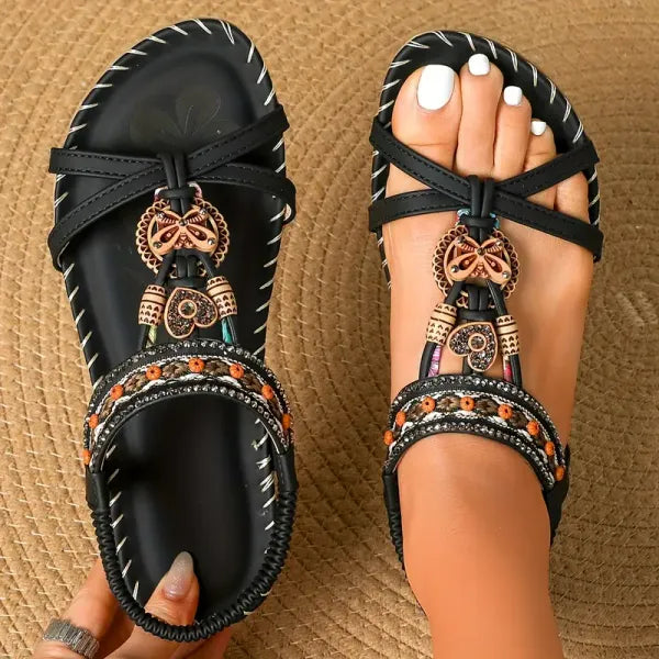 Platte dames sandalen met decoratieve kralenversiering en kruisbandjes op natuurlijke ondergrond