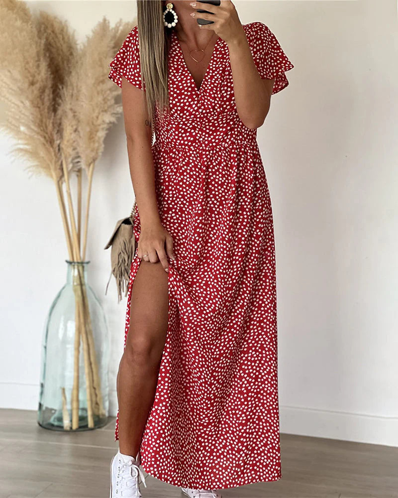 Detail van V-halslijn en korte volantmouwen op polkadot maxi jurk met aangetailleerde taille