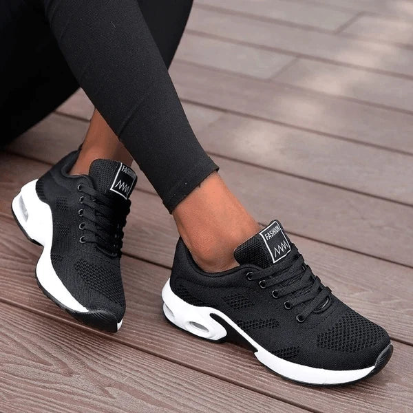 Zijaanzicht van sportieve dames sneakers met vetersluiting en witte zool met luchtkussen