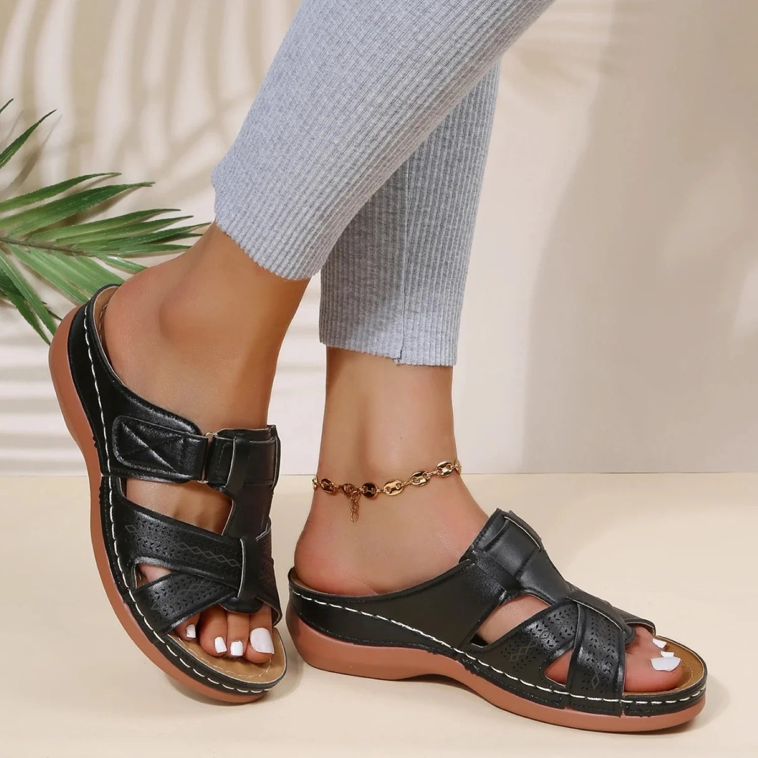 Dames sandalen met gesp en open teen in zwart met contrasterende stiksels en decoratieve perforaties