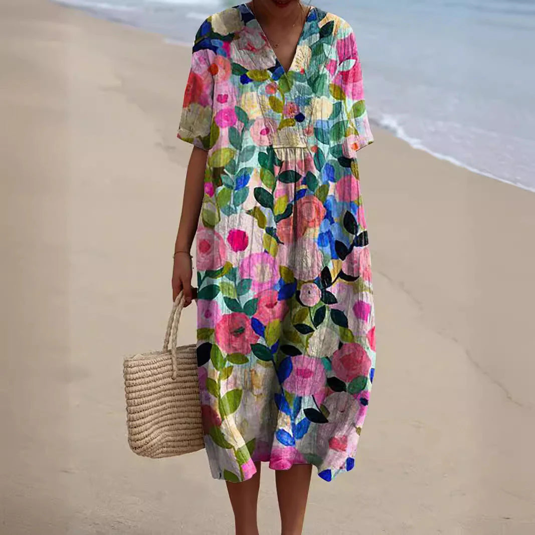 Vrouw draagt zomerjurk met kleurrijke bloemenprint en midi-lengte op het strand