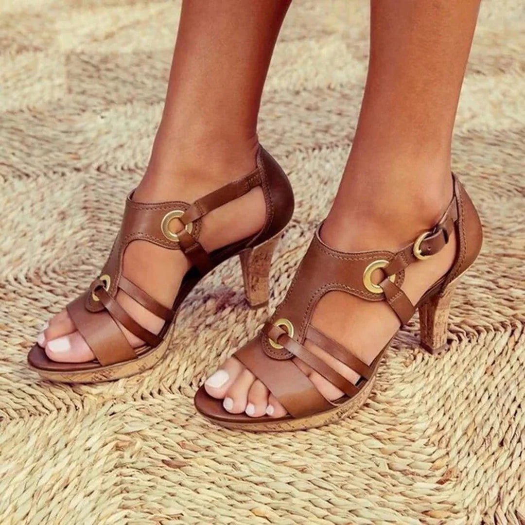 Detail van riempjes en gesp sluiting op dames sandalen met sleehak