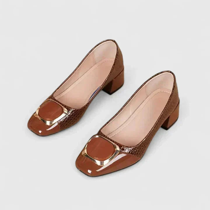 Volledige weergave van bruine dames pumps met blokhak en gouden detail op witte achtergrond