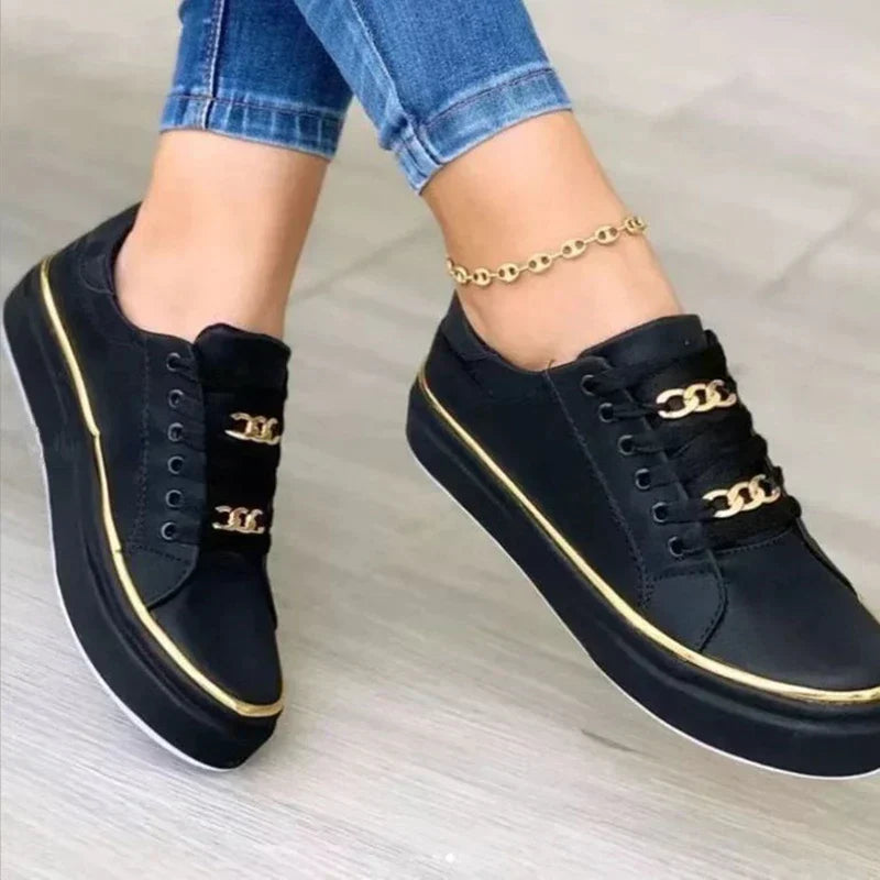 Dames platform sneakers met gouden kettingdetails en dikke verhoogde zool gedragen met blauwe jeans