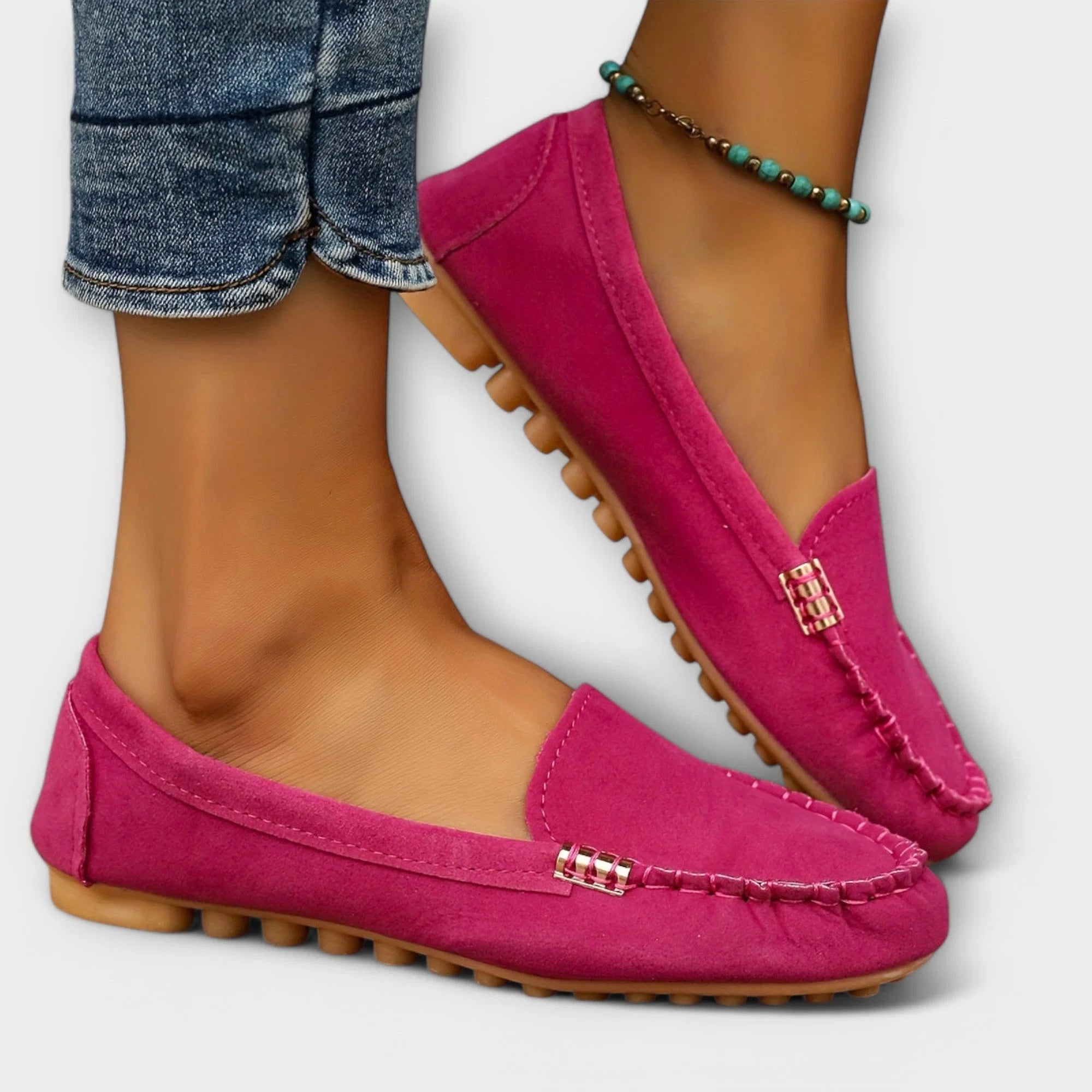 Close-up van roze loafers met decoratieve stiksels en ondersteunende zool