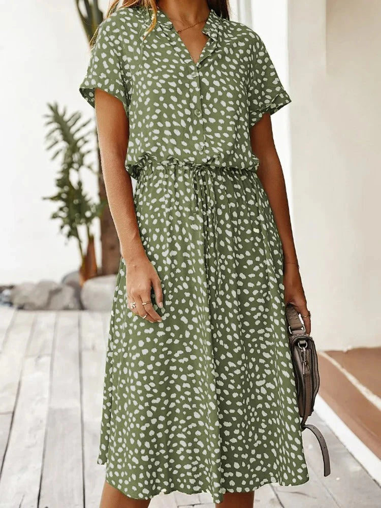 Close-up van V-hals en knoopsluiting op midi zomerjurk met stippenprint