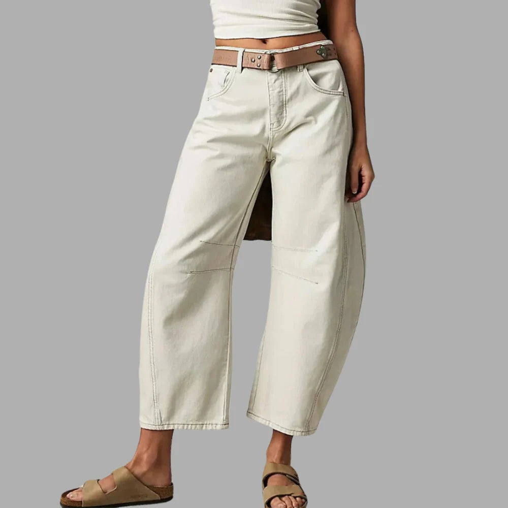 Close-up van knoopsluiting en taille van barrel jeans met gevlochten riem
