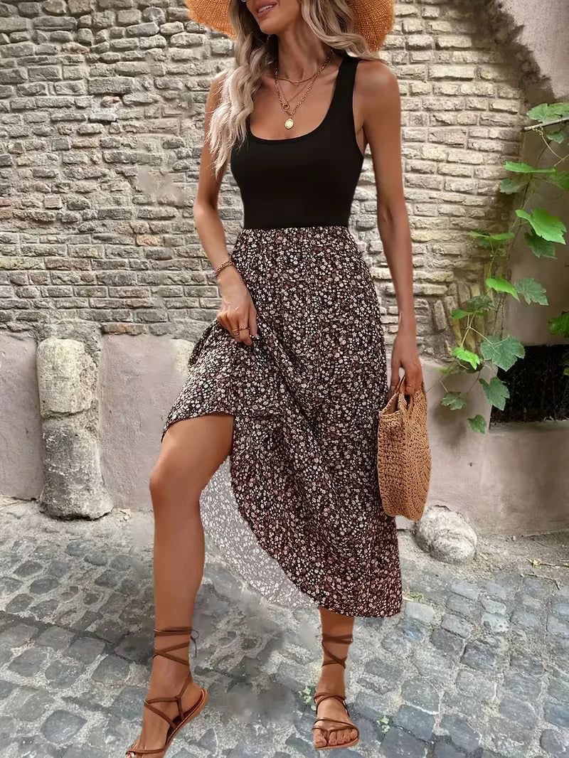 Mouwloze maxi jurk met zwart bovenstuk en bruine bloemenprint rok gedragen met strohoed