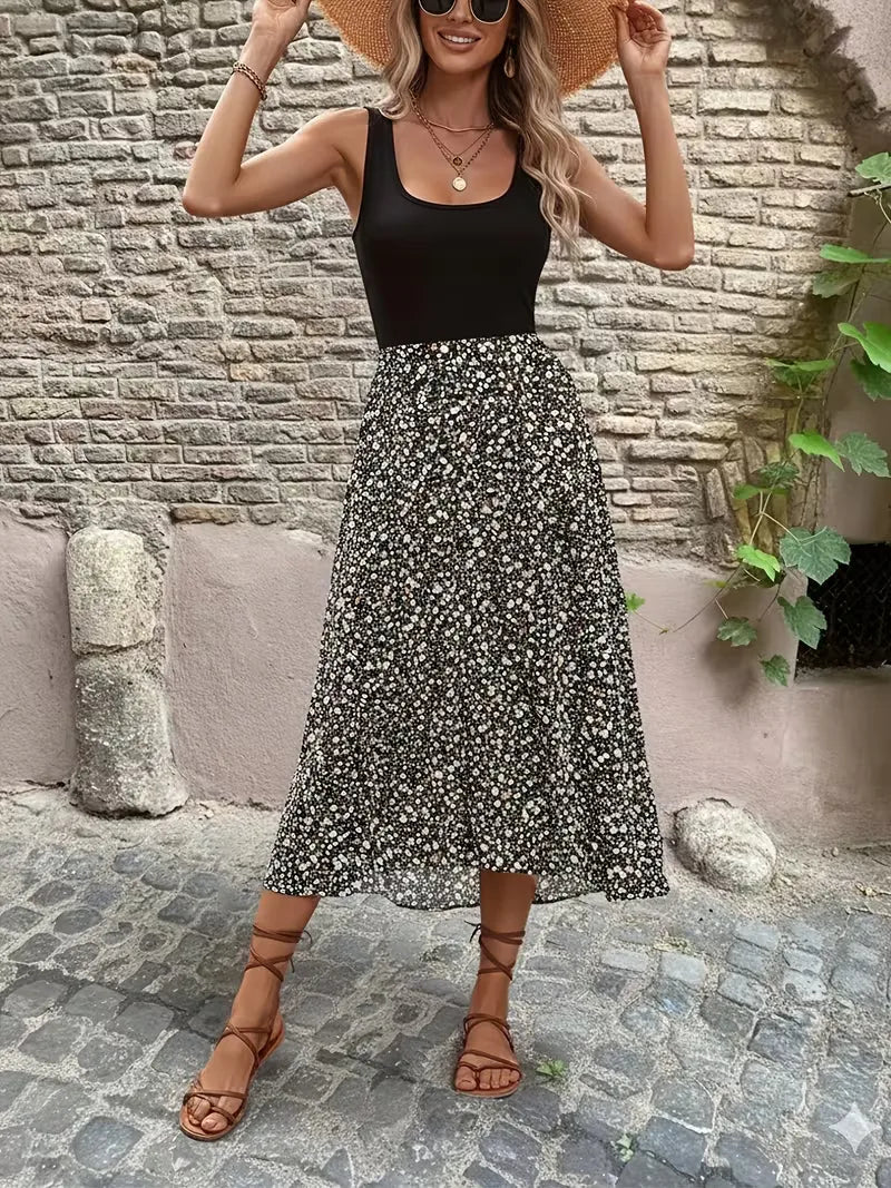 Mouwloze maxi jurk met contrasterende bloemenprint gedragen met rieten tas en sandalen