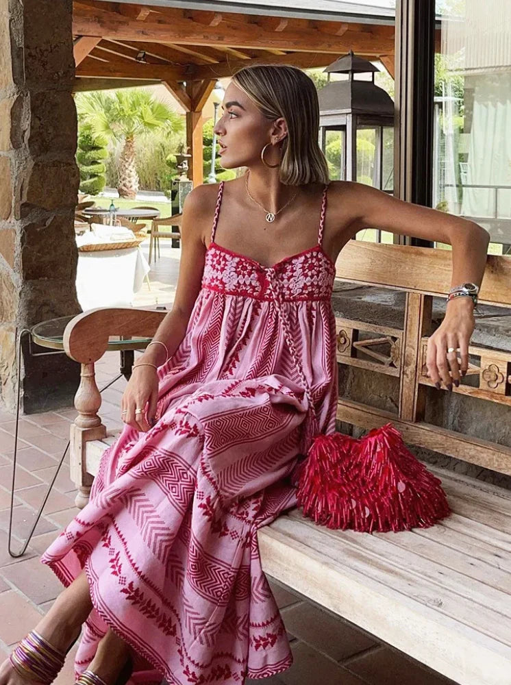 Vrouw poseert in maxi zomerjurk met bandjes en romantische print