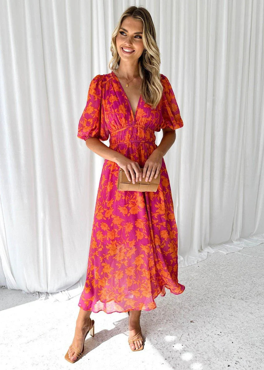 Midi jurk met bloemenprint in roze en oranje tinten, pofmouwen en V-hals, gedragen met sandalen