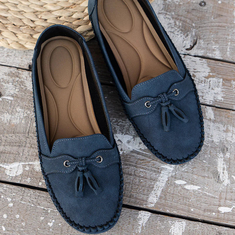 Close-up van dames loafers met strikdetail en handgestikte rand in donkerblauwe kleur