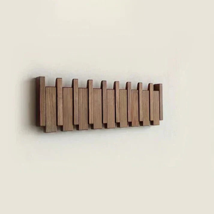 Houten piano kapstok met jassen en tassen opgehangen in moderne entree