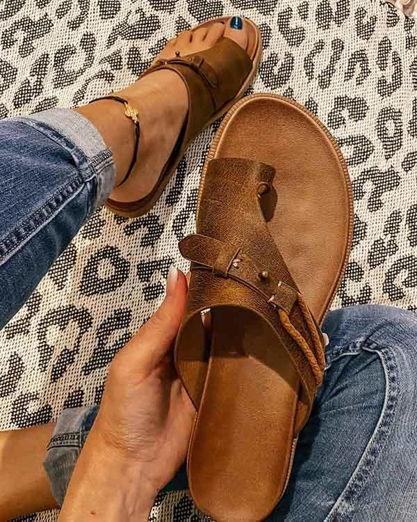 Dames leren slippers met teensluiting en verstelbare bandjes in bruine kleur gedragen met spijkerbroek