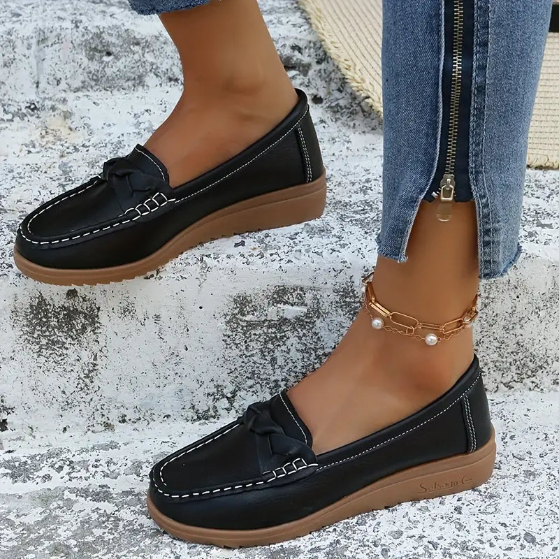 Zijaanzicht van dames loafers met contrasterende witte stiksels en licht verhoogde hiel in marineblauw