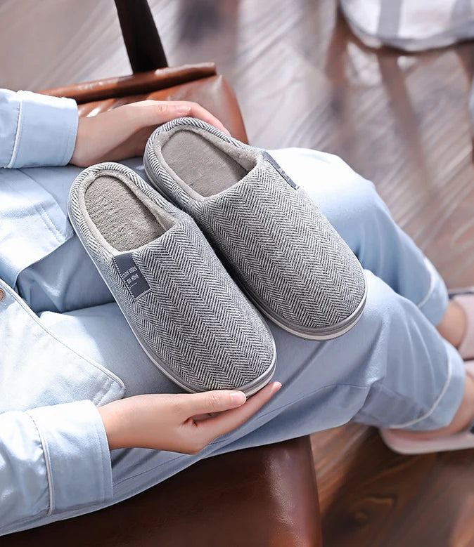 Heren pantoffels met visgraatpatroon geplaatst naast mand, stijlvolle binnenschoenen voor ontspannen momenten thuis