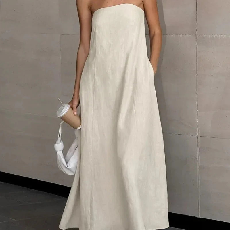 Detail van strapless halslijn van witte maxi jurk met luchtige lijnvoering