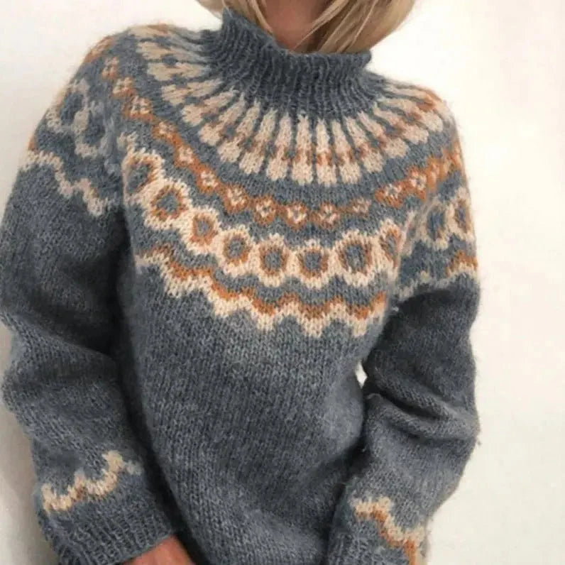 Detailopname van het traditionele Noordse jacquardpatroon in aardse tinten op de gebreide coltrui voor dames