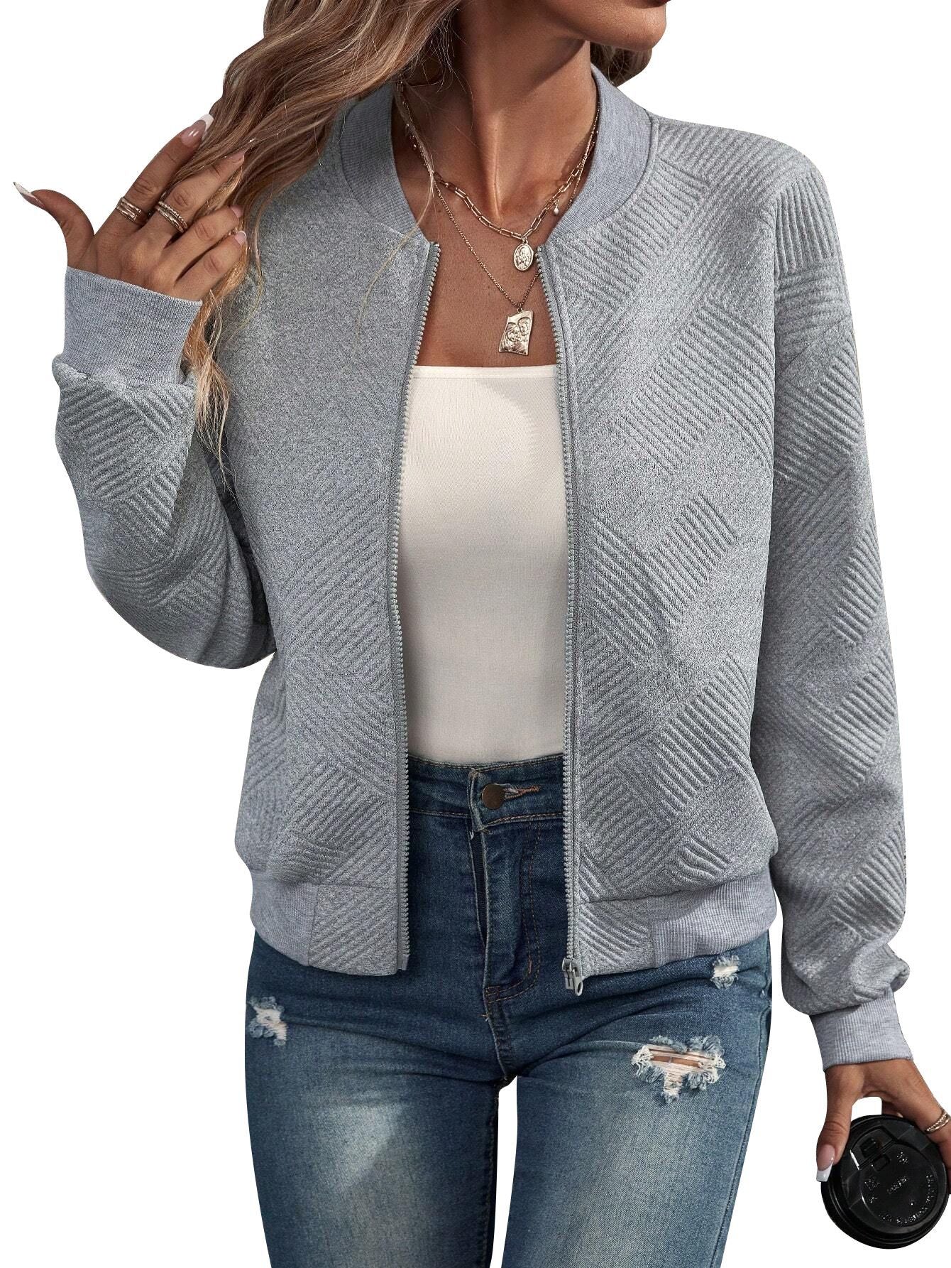 Dames bomberjack in grijs gedragen met een witte top en jeans voor casual stijl