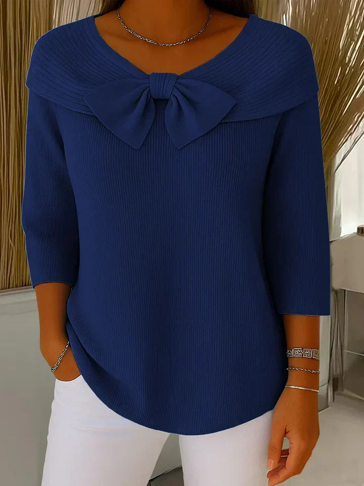 Volledige look van de elegante gebreide top met strik gecombineerd met witte broek