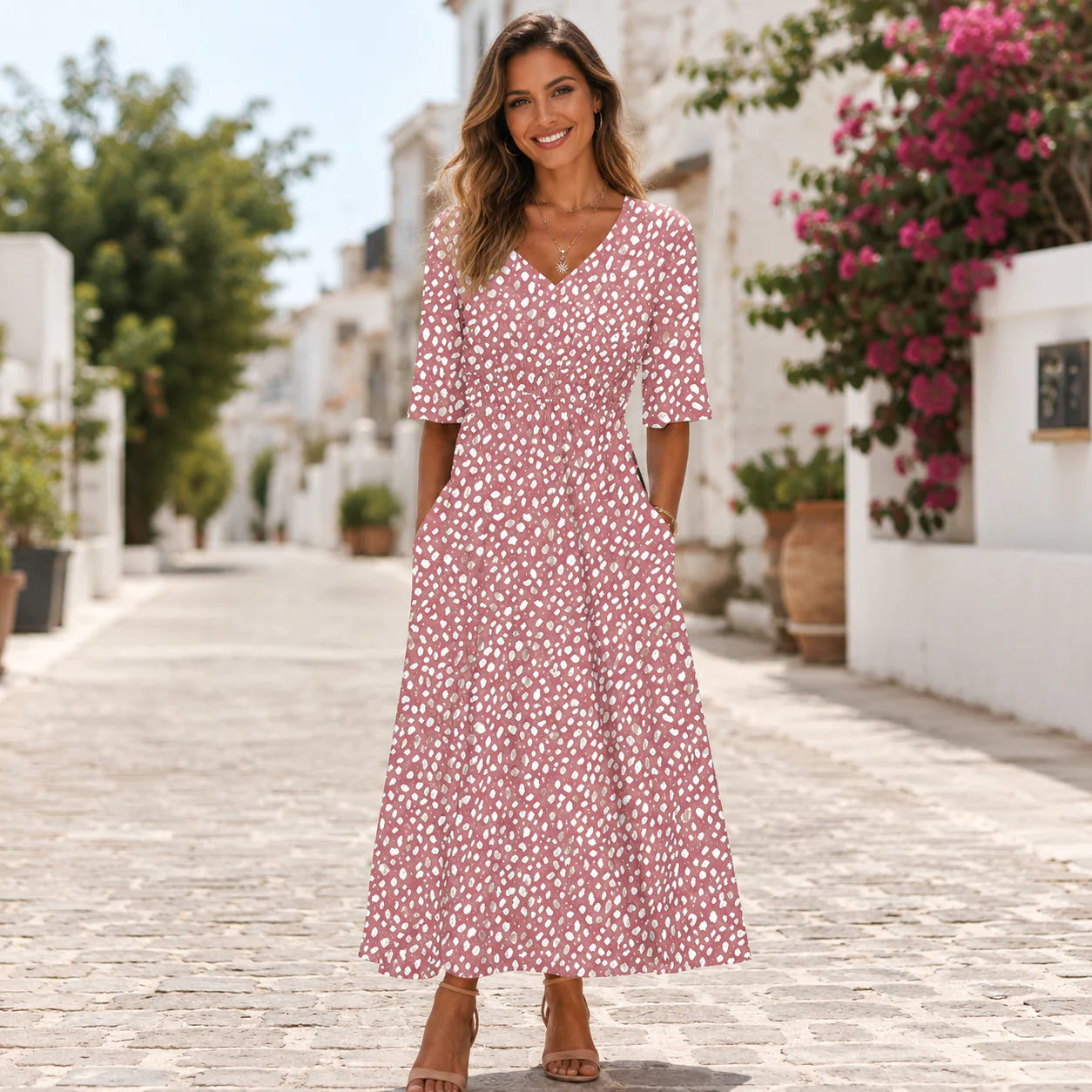 Detail van midi jurk met stippenprint en korte mouwen in roze tinten