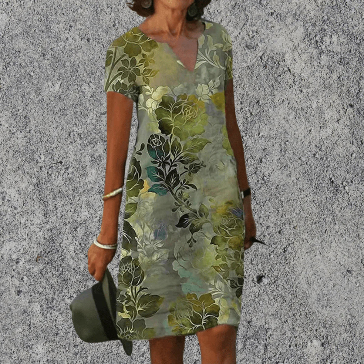Vrouw draagt een groene midi zomerjurk met bloemenprint en V-hals voor zomerse gelegenheden