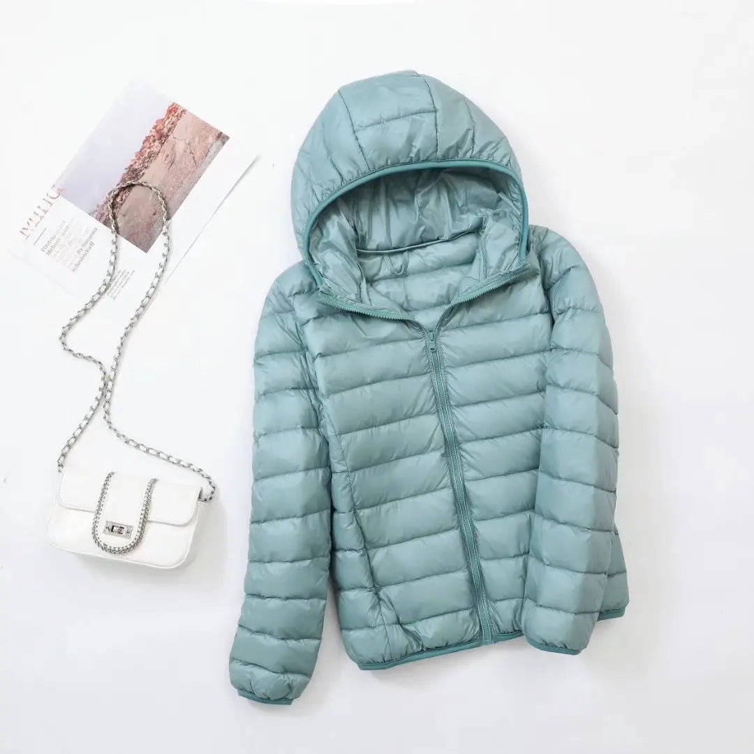 Dames puffer jas met capuchon gedragen met witte handtas voor winteroutfit inspiratie