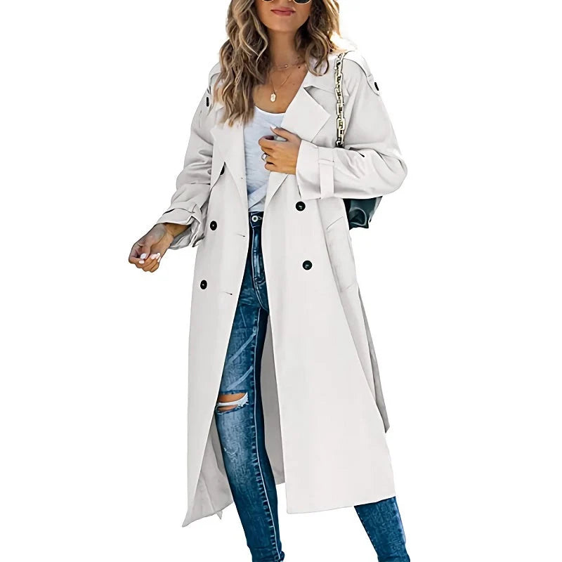 Dames lange trenchcoat met dubbele knoopsluiting en ceintuur gedragen over spijkerbroek