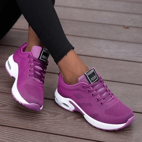 Close-up van dames sneakers met luchtkussen-zool en ademende mesh constructie in rood