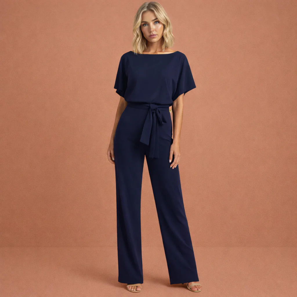 Close-up van strikceintuur en boothals detail op beige jumpsuit