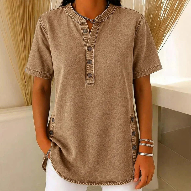 Close-up van V-hals met knoopsluiting op dames denim tuniek in lichtblauw