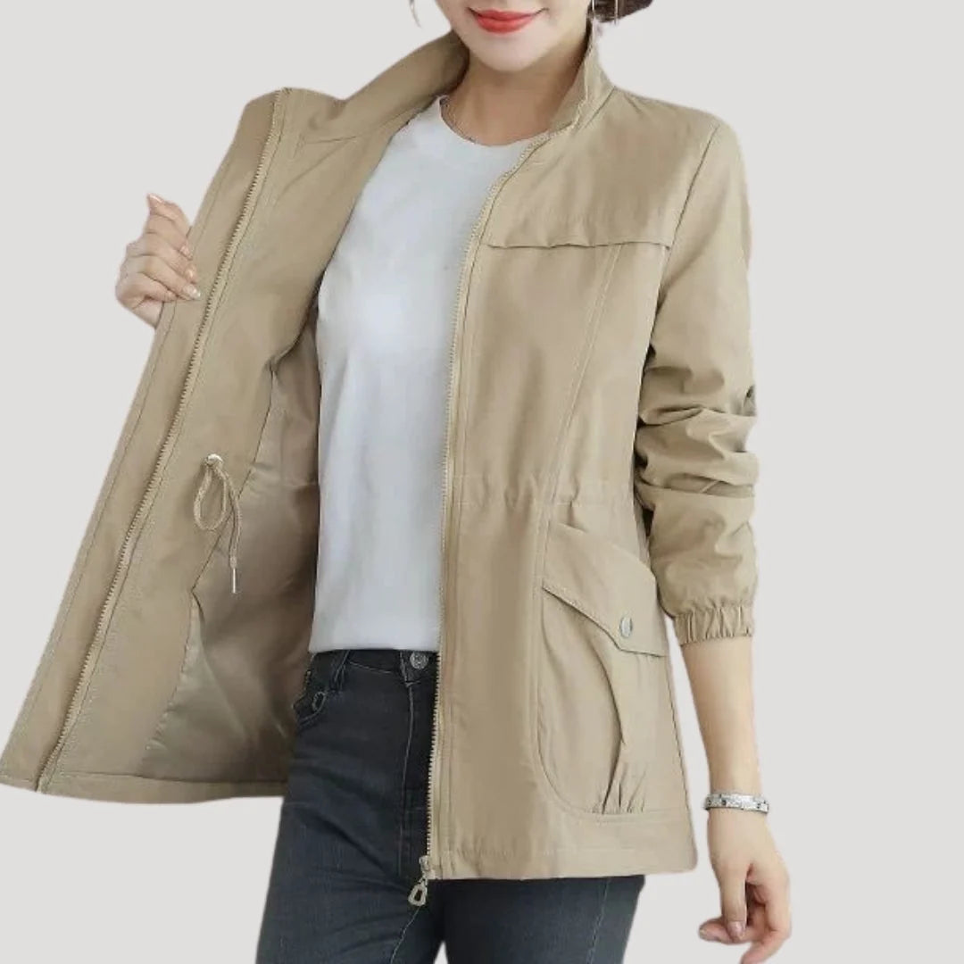 Dames bomberjas in beige met verstelbare taille en ritssluiting gedragen over een wit shirt