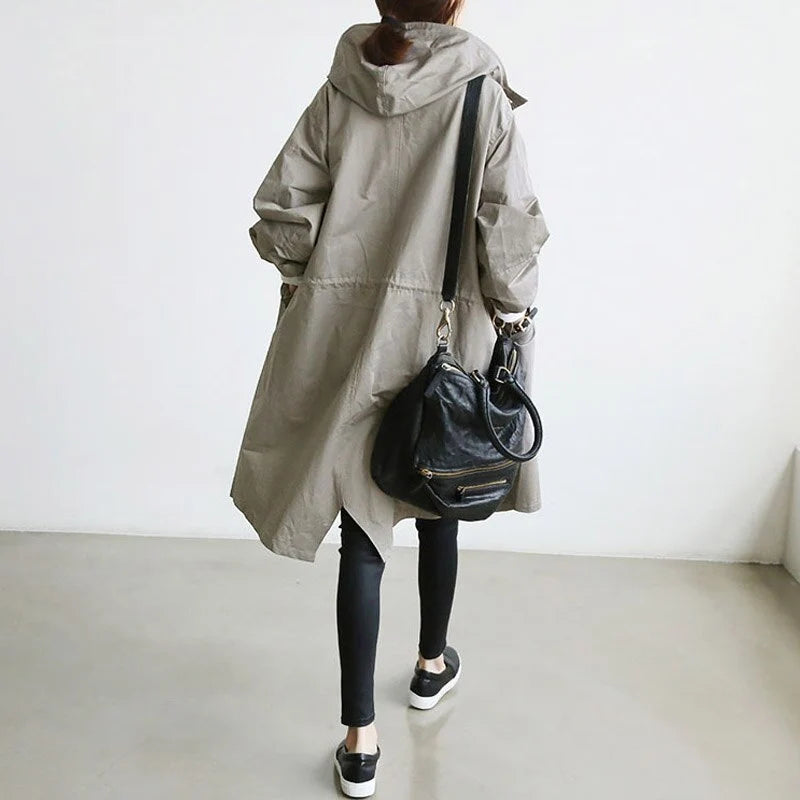 Dames lange jas met capuchon in beige, zijkant met praktische zakken en relaxte silhouet