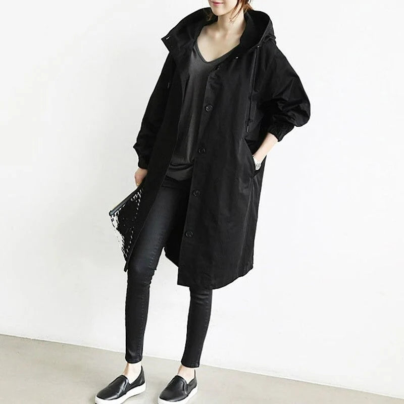 Detail van capuchon met trekkoord en knoopsluiting op dames lange jas voor wisselvallig weer