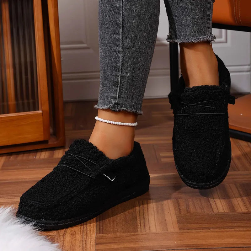 Dames draagt zachte teddy pantoffels met grijze skinny jeans voor een casual thuislook
