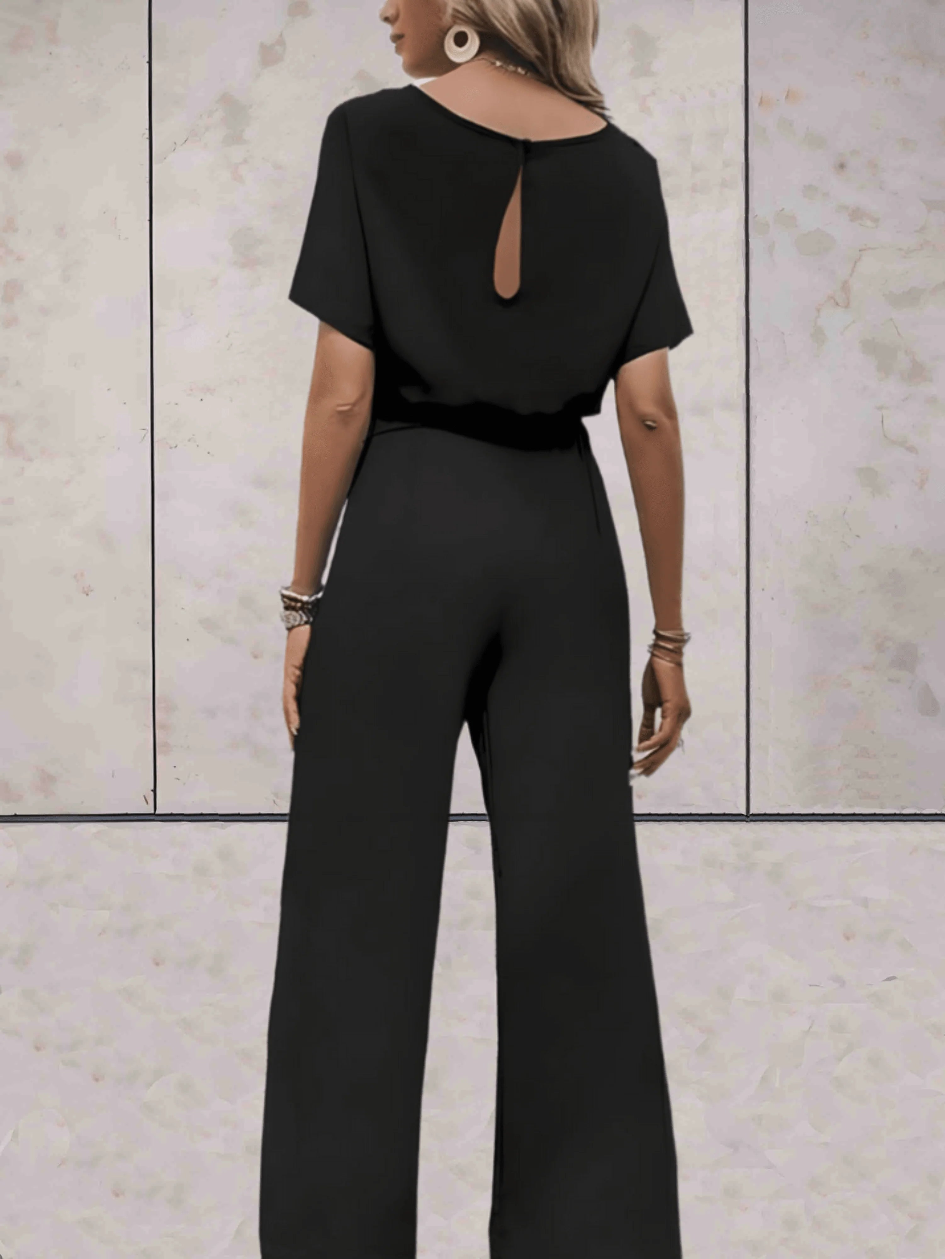 Detail van jumpsuit met strikceintuur in de taille en rechte broekpijpen