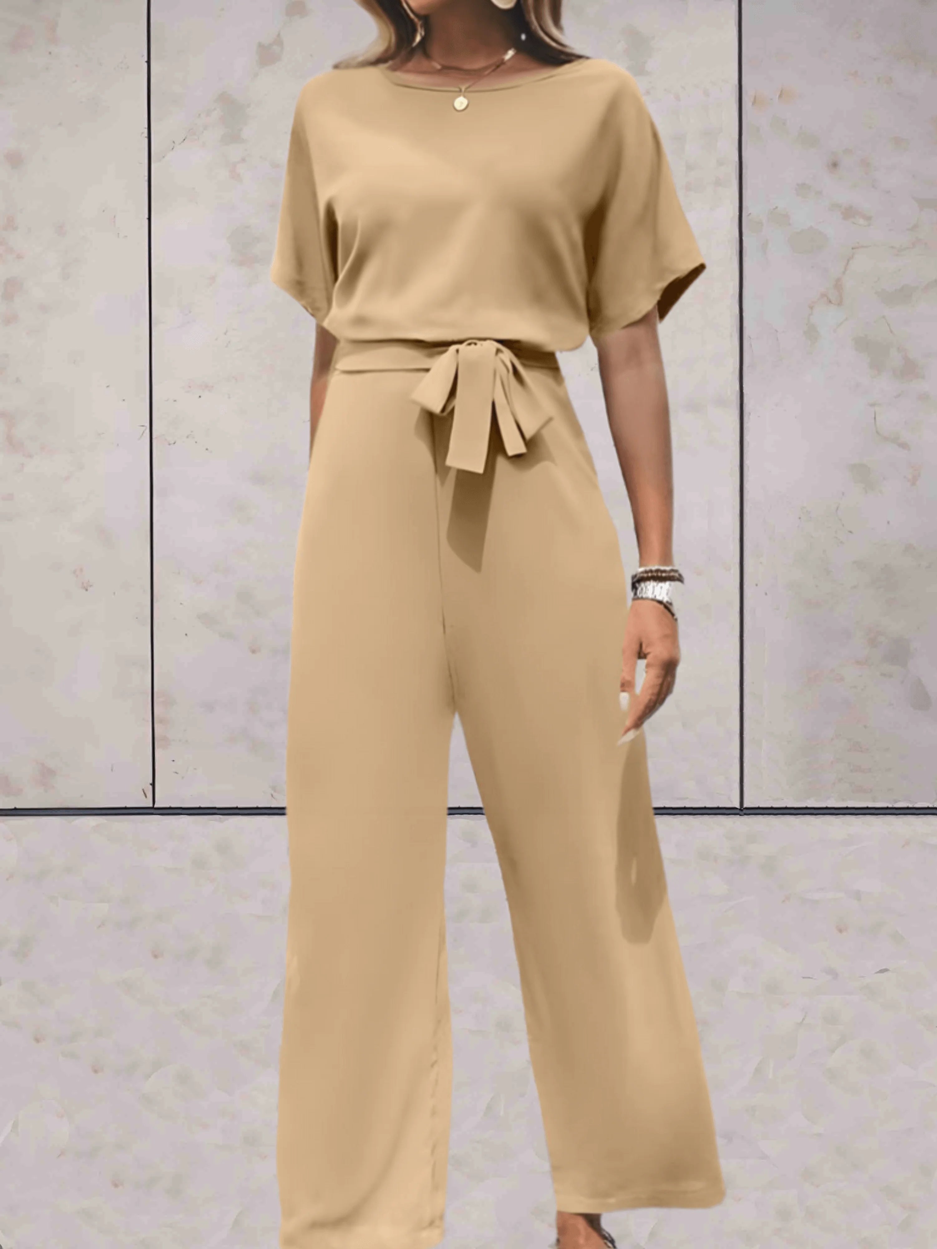 Achterzijde van jumpsuit met vlakke afwerking en ceintuur detail
