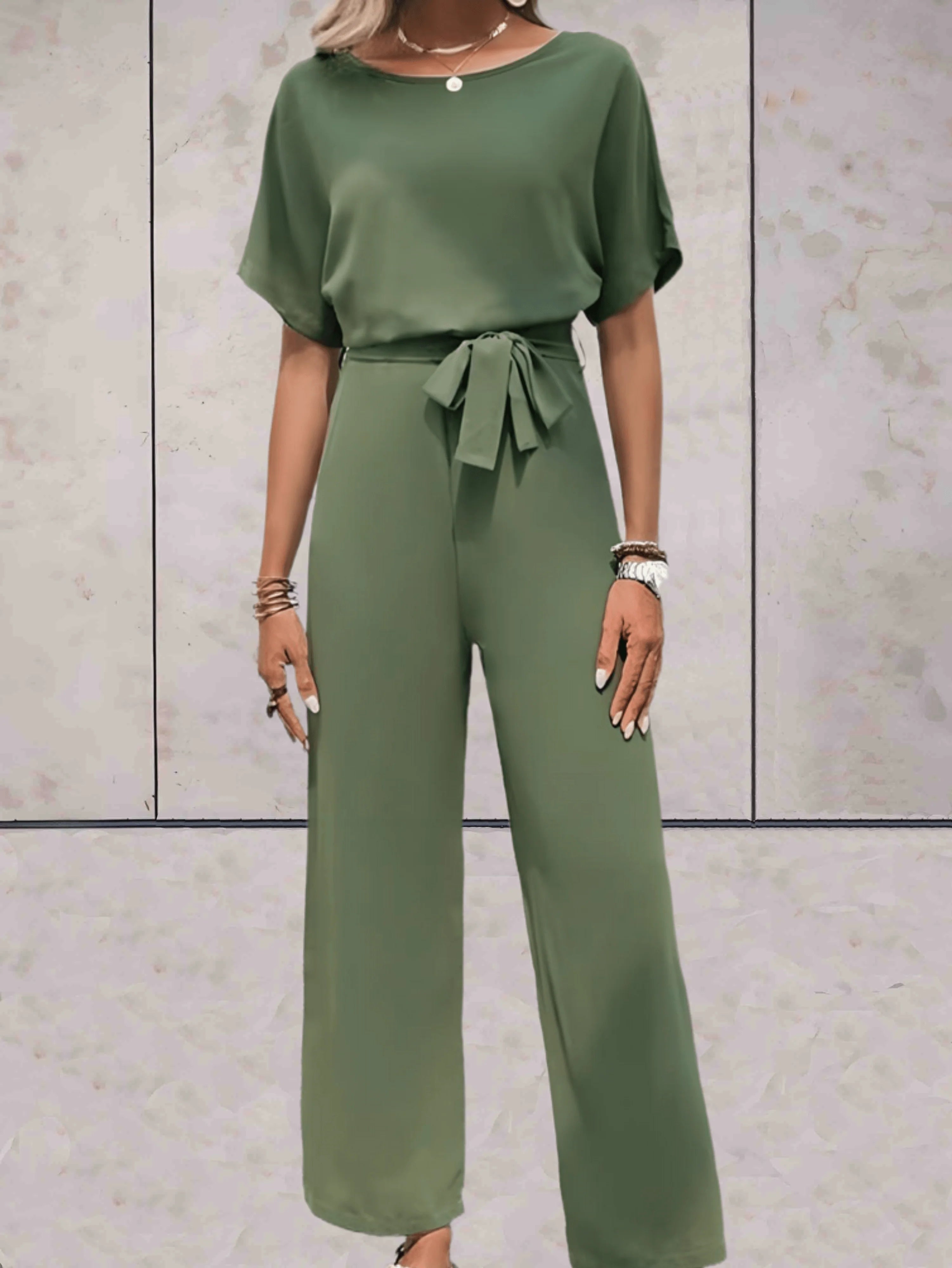 Jumpsuit gecombineerd met minimale accessoires en neutrale achtergrond