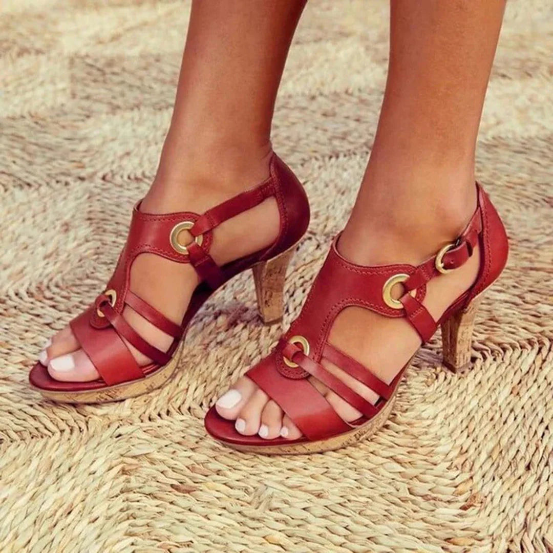 Close-up van zwarte dames sandalen met T-strap riempjes en metalen gesp details