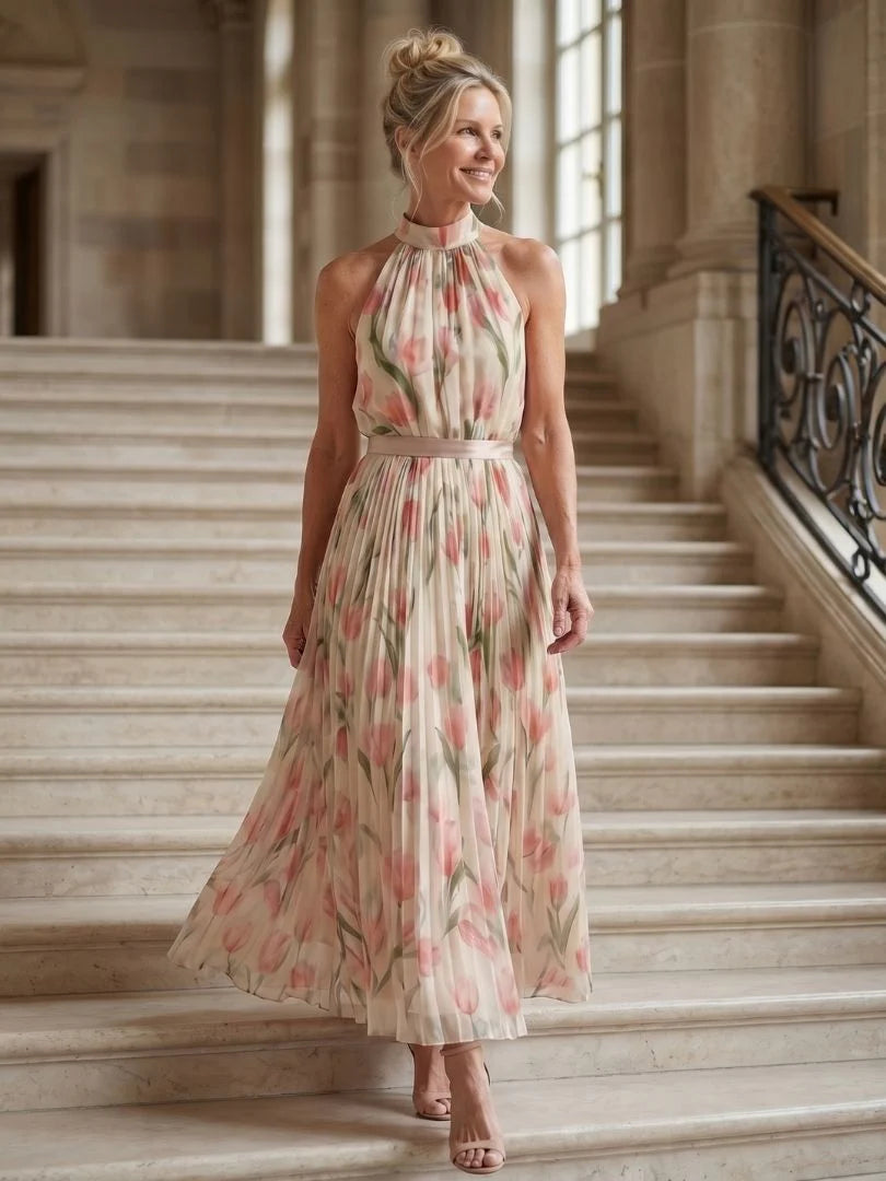 Model toont beweging van geplisseerde rok op halter midi jurk