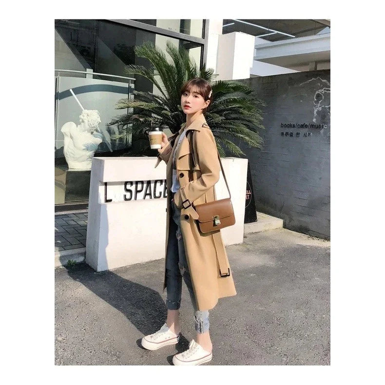 Achterkant van beige trenchcoat met rugdetail en verstelbare manchetten