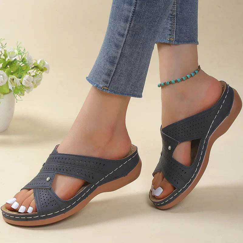 Vooraanzicht van zwarte sandalen met kruisbanden en licht verhoogde zool