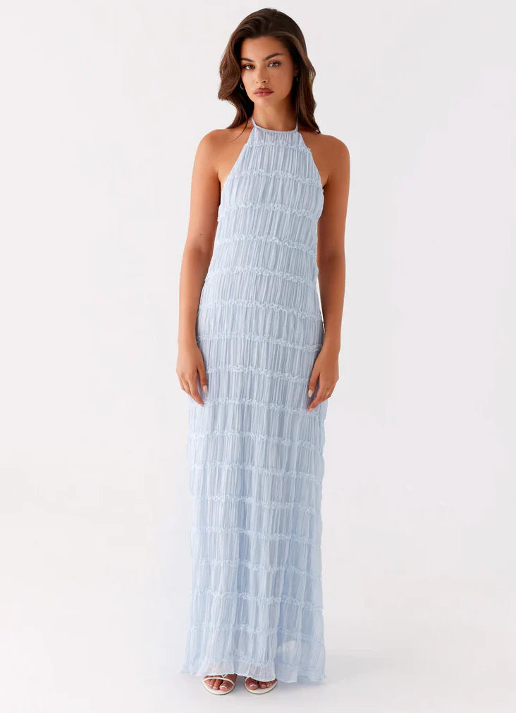 Zijaanzicht van witte halter maxi jurk met gelaagde franjes en flatterende maxi lengte