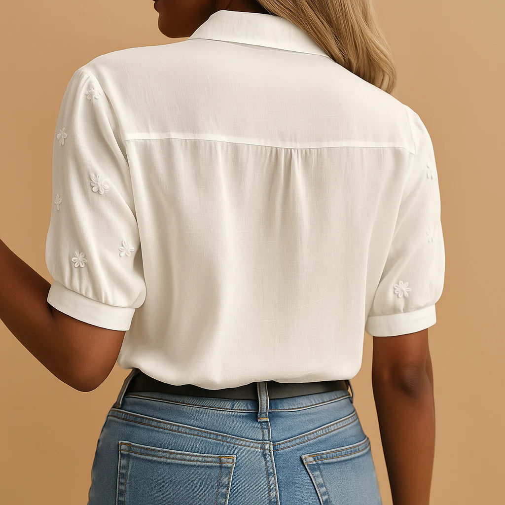 Detail van de broderie-inzet en ritssluiting op de dames blouse met korte mouwen