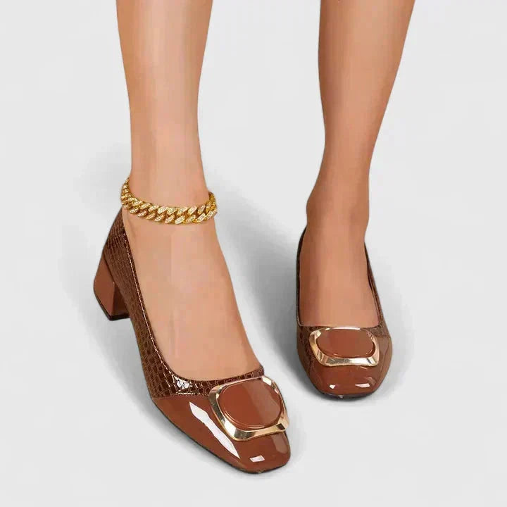 Close-up van croco reliëf structuur op bruine dames pumps met blokhak