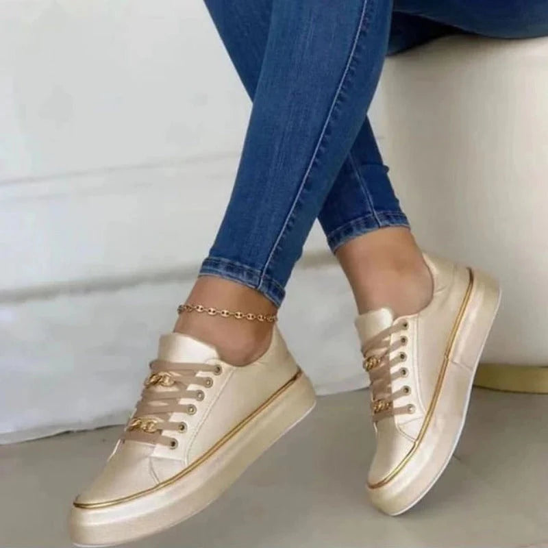 Close-up van platform sneakers met vetersluiting en gouden details op dikke zool